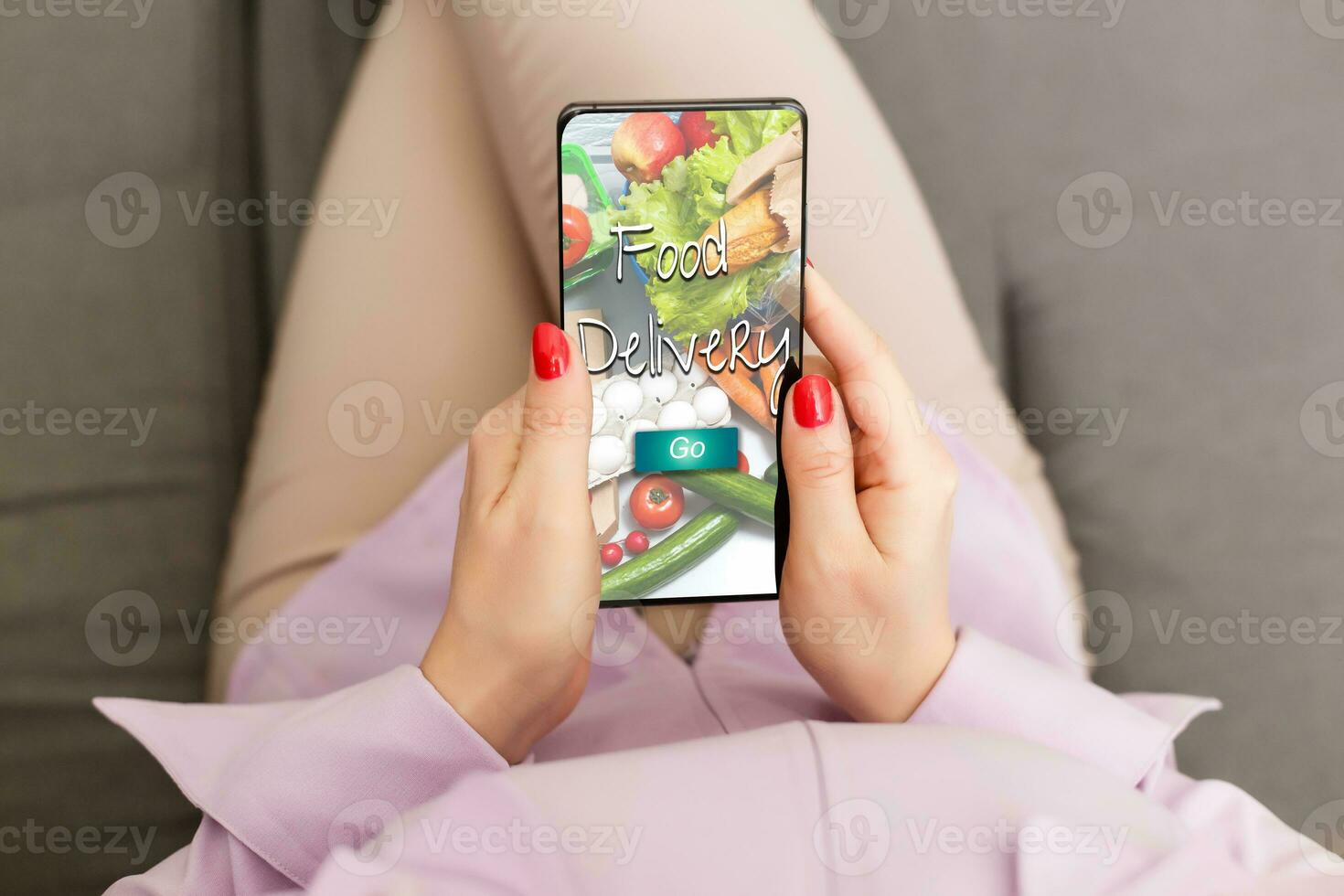 Mädchen Bestellung Pizza online auf Smartphone, mit Tabelle und Kaffee und Pflanze im Hintergrund foto