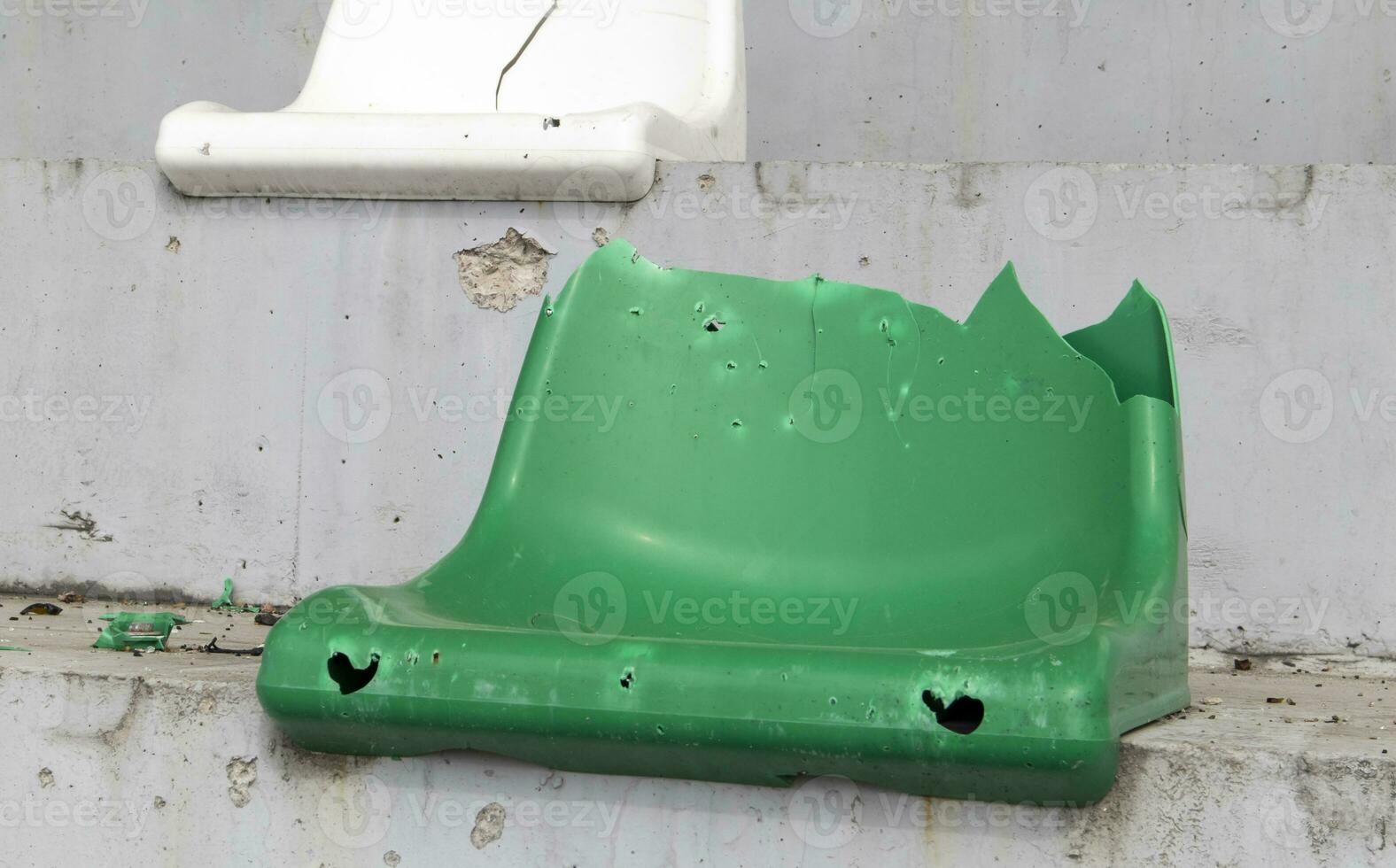 Krieg im Ukraine. gebrochen Plastik Bänke zum Fans auf das Podium, im ein zerstört Fußball Stadion im ein Kinder- Fußball Schule. das Konsequenzen von Beschuss von Artillerie. foto