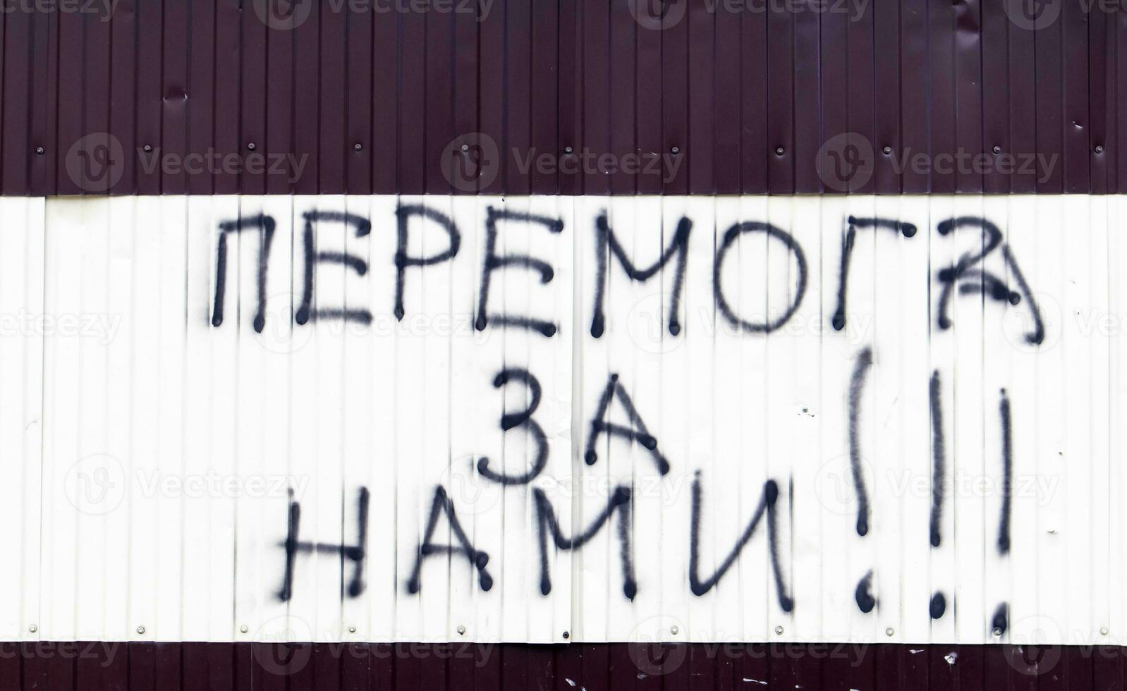 das Text auf das Mauer ist gemalt mit schwarz sprühen malen. Übersetzung - - Sieg ist unsere. patriotisch Text im ukrainisch. das Konzept von Frieden, Nein Krieg, Sieg im Krieg. foto