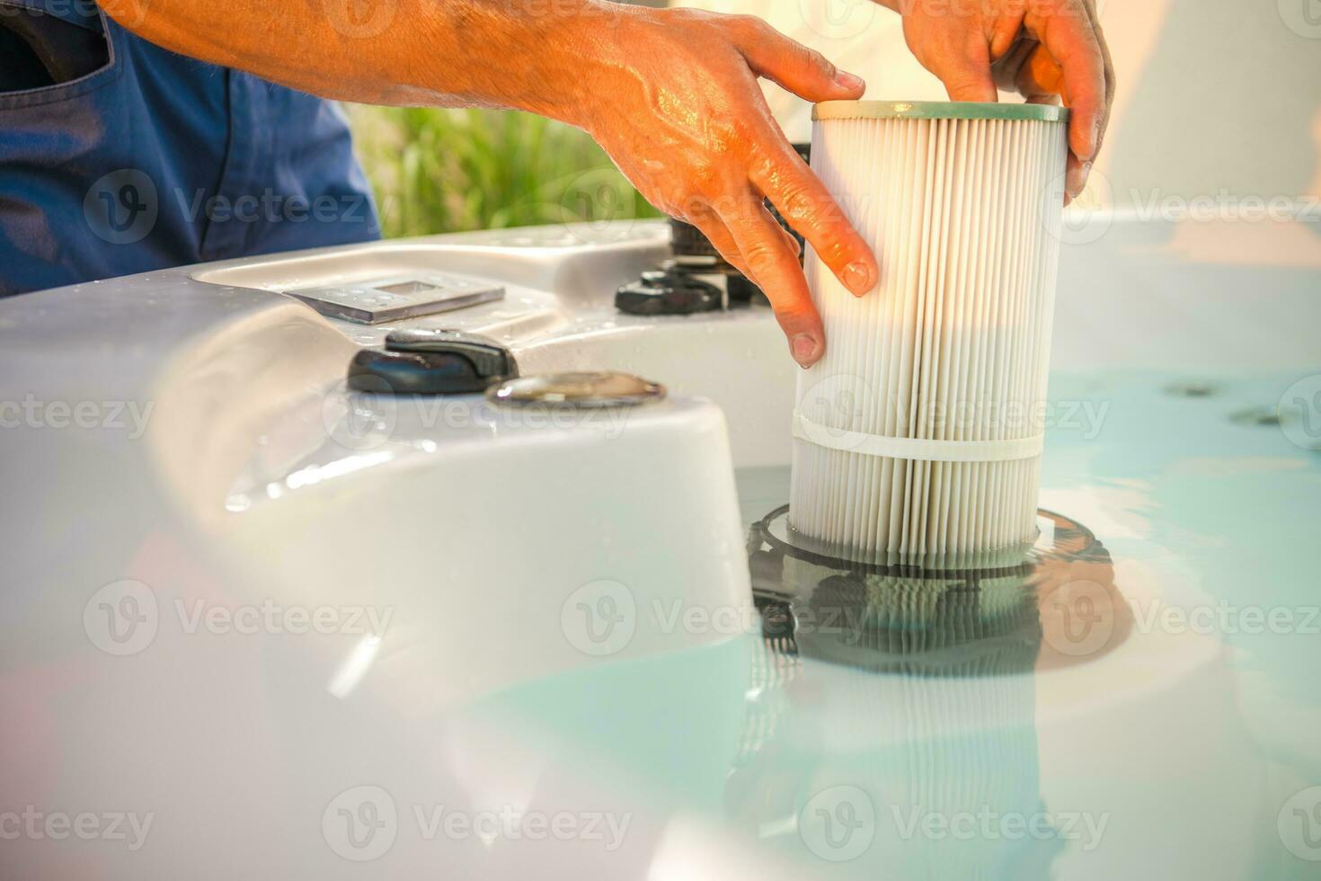 heiß Wanne Techniker entfernen Wasser Filter und durchführen geplant Garten Spa Instandhaltung foto