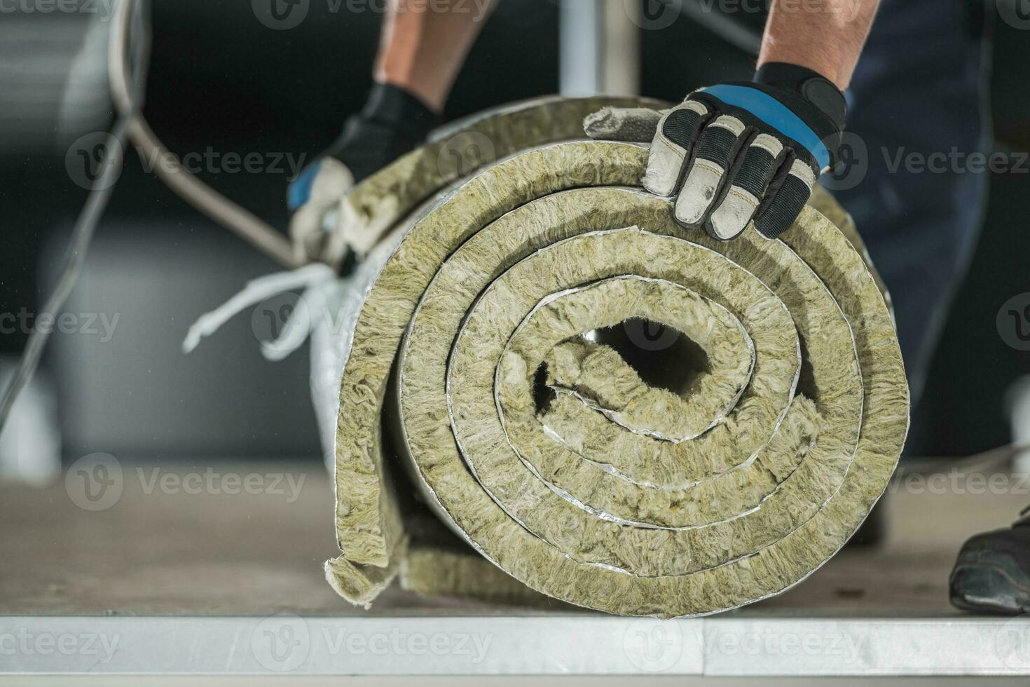 Konstruktion Arbeiter vorbereiten rollen von Mineral wolle Isolierung foto