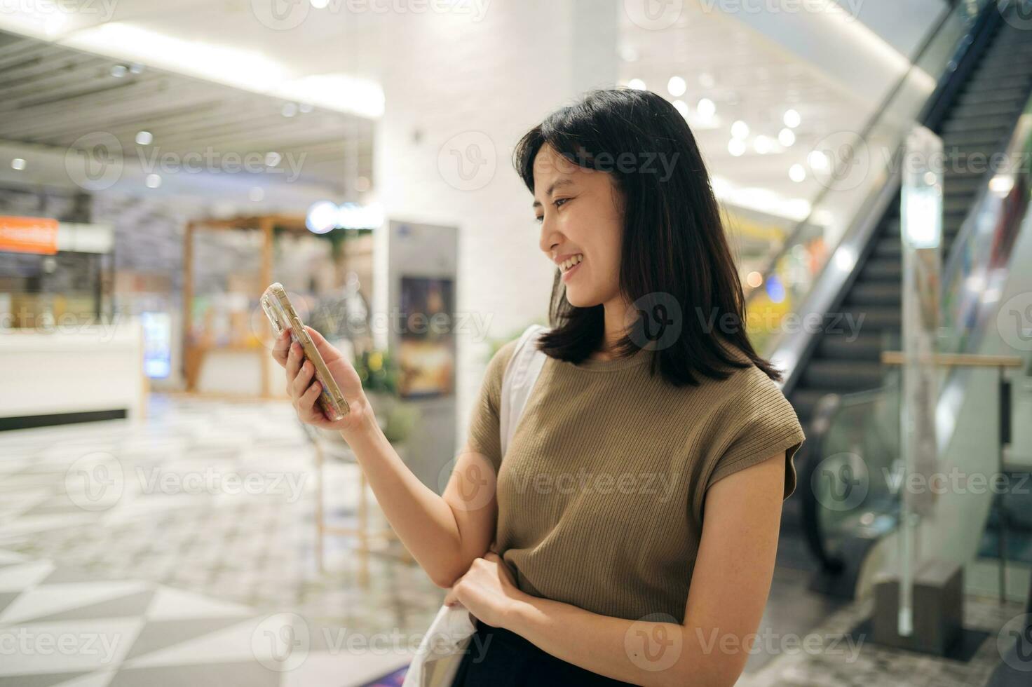 Porträt schön jung asiatisch Frau mit Clever Handy, Mobiltelefon Telefon im Cafeteria beim Einkaufen Einkaufszentrum. foto