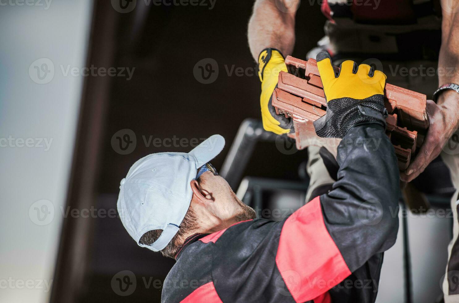 männlich Auftragnehmer Entladung Keramik Dach Fliese. foto