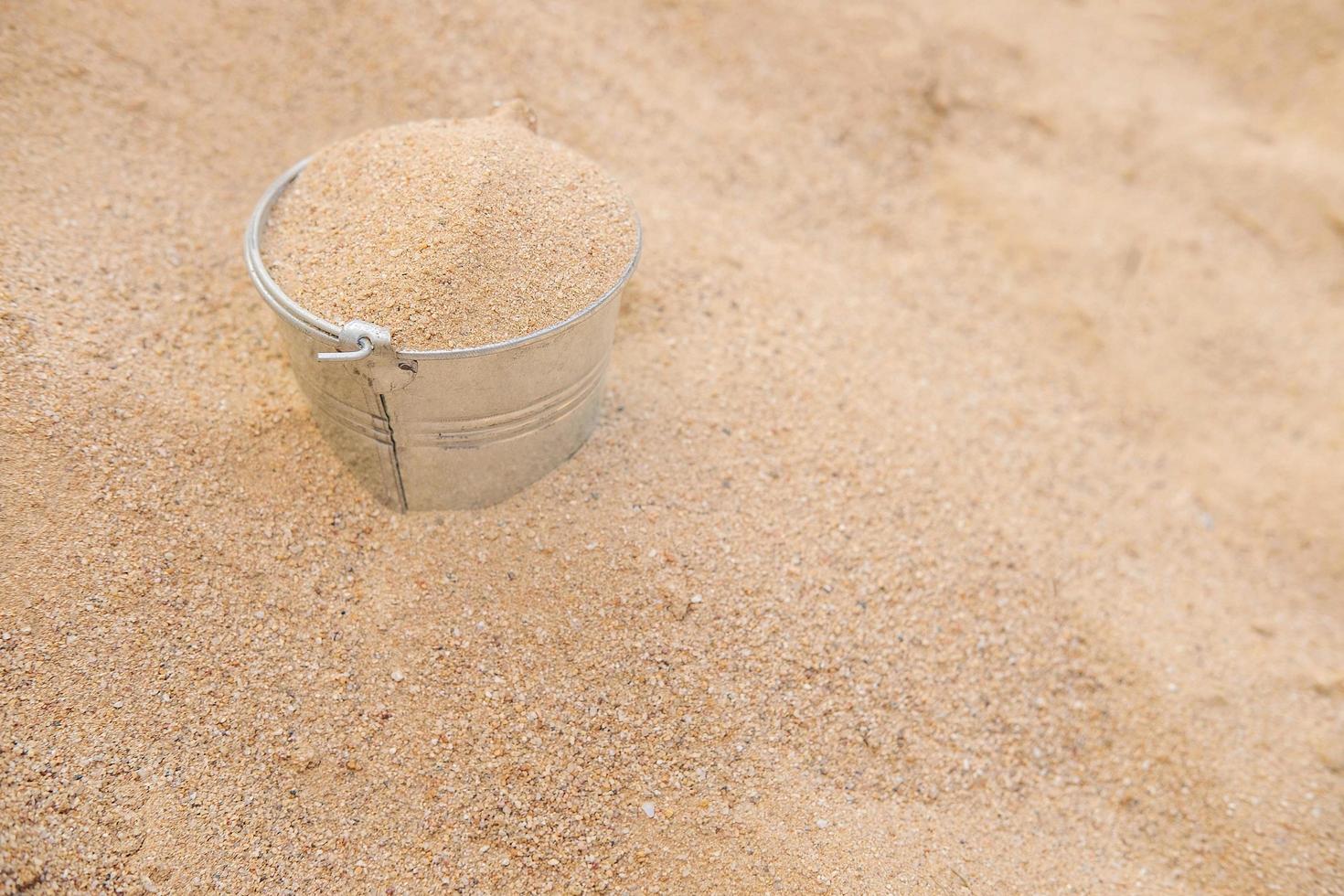 Eimer im Sandhaufen foto