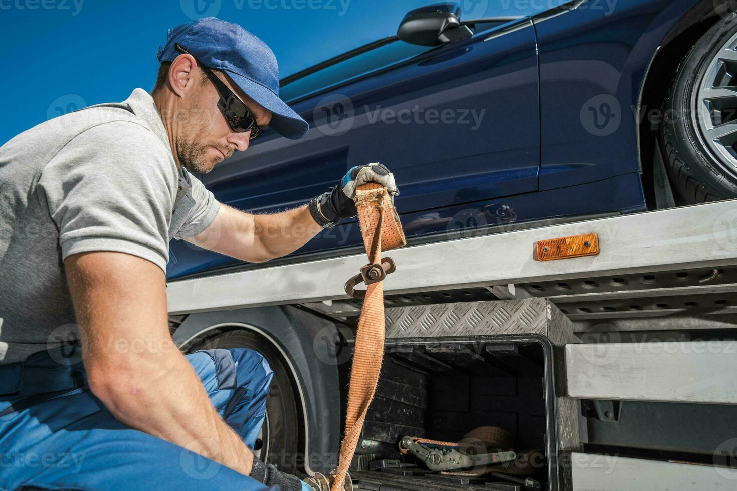 Arbeiter Sicherung zurückgenommen Fahrzeug auf seine Abschleppen LKW foto