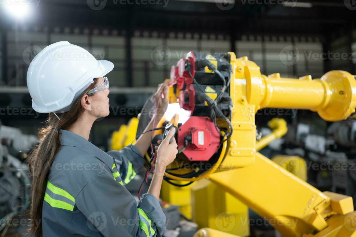 im das Roboter Lagerhaus, ein weiblich Ingenieur inspiziert das elektrisch System von jeder Robotik Arm, Vor liefern zu das Kunde. foto