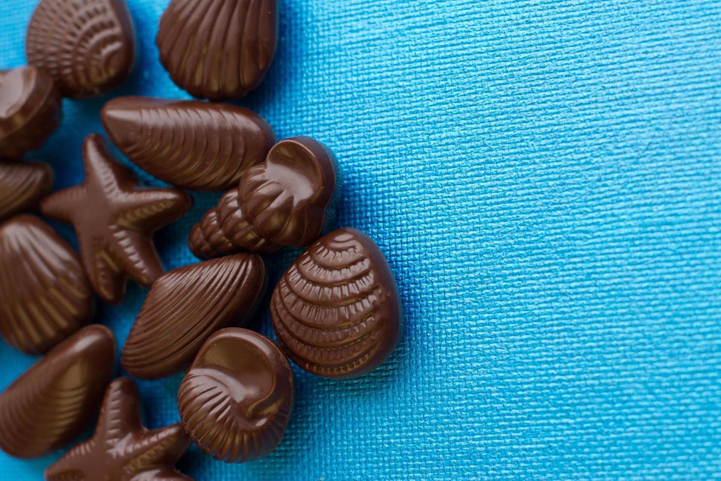 belgische muschelförmige Pralinen auf blauem Hintergrund foto