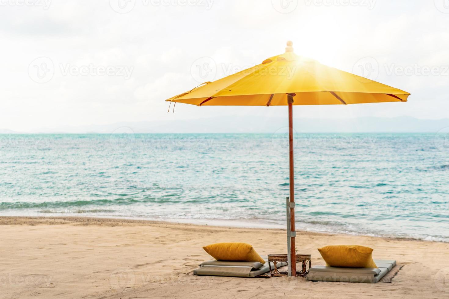 Dolden und Stuhl am tropischen Sommerstrandhintergrund foto