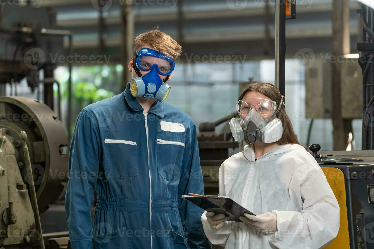 Notfall Verschmutzung Fabrik Konzept. Porträt Ingenieur tragen ein mechanisch Overall und Gas Maske suchen beim das Kamera mit seine Waffen gekreuzt. foto