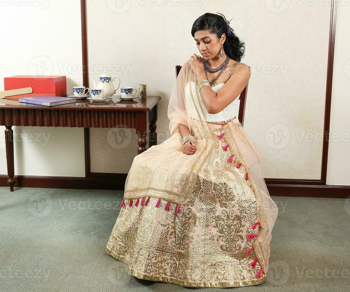 schön jung Frau tragen modern indisch Lehenga hgagra Knöchel Länge Rock Kleid posieren Zuhause retro Jahrgang foto
