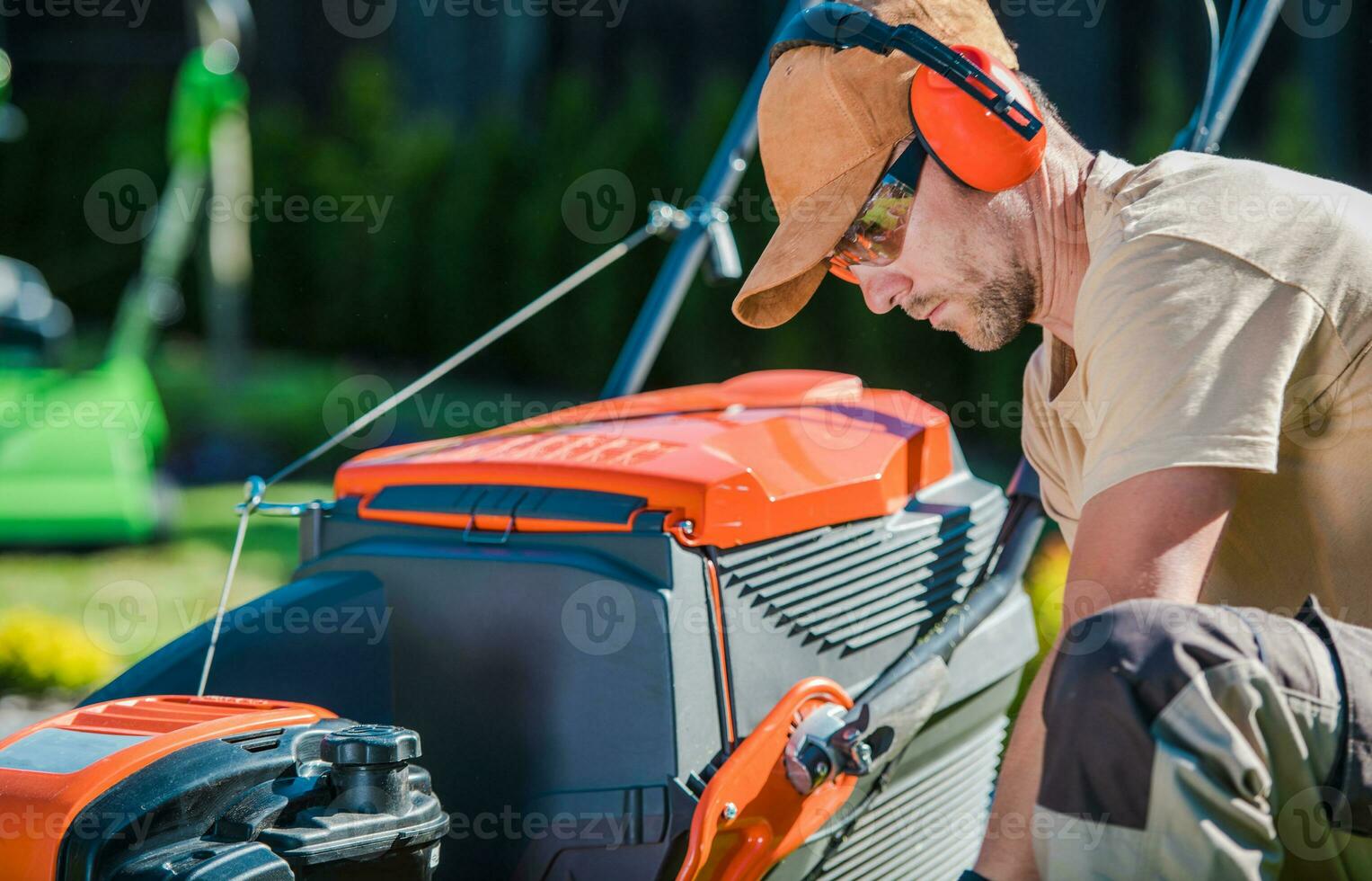 Fachmann Gärtner Überprüfung seine Rasen Mäher Vor beginnend das Garten Arbeit foto