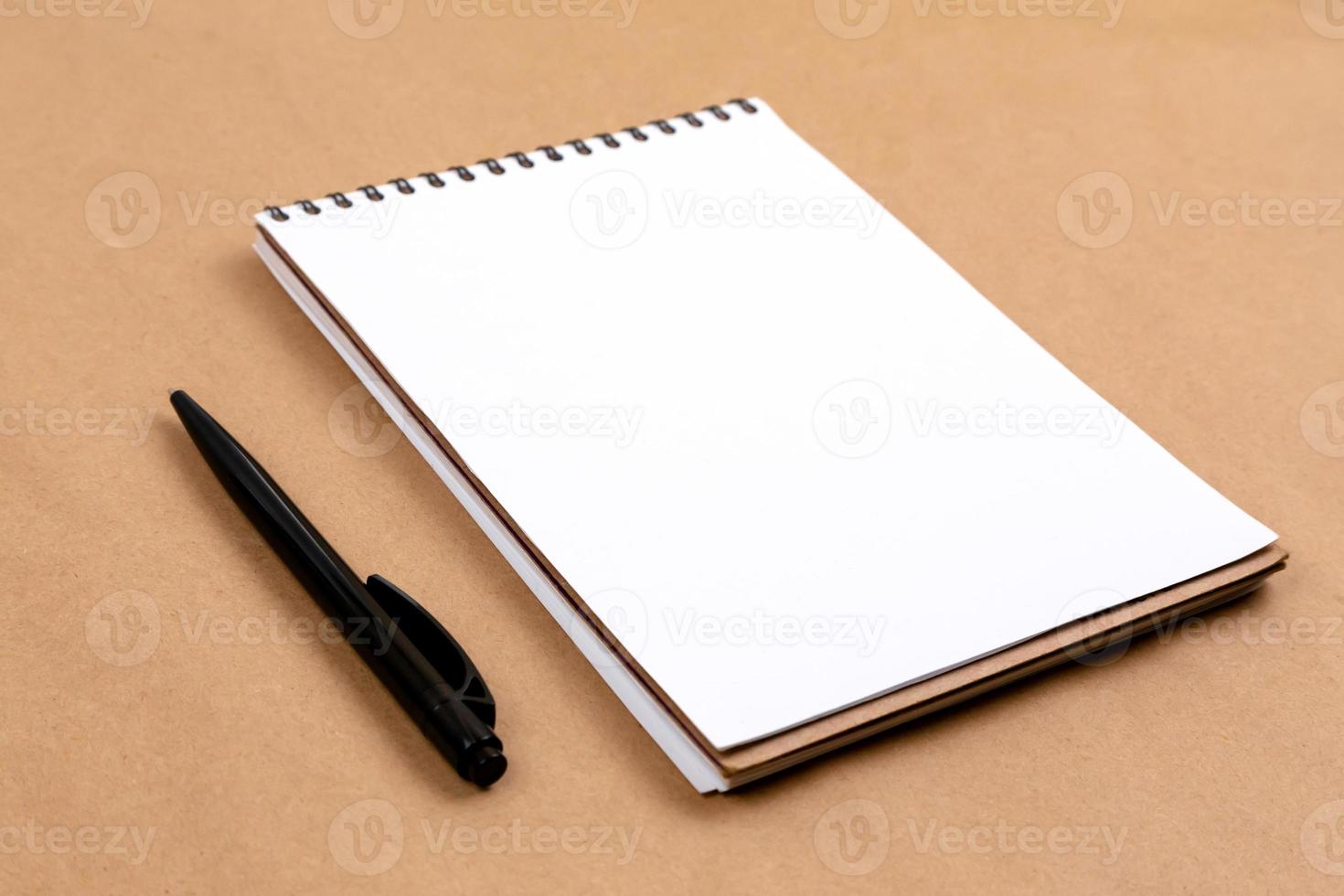 flaches Draufsichtfoto eines Bleistifts und eines Notizblocks auf einem beigen Hintergrund foto