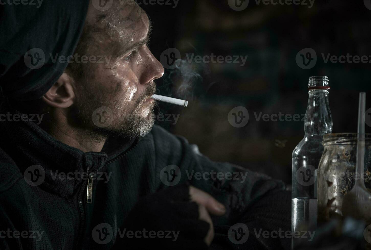 obdachlos Männer mit Zigarette und Flasche von Wodka foto