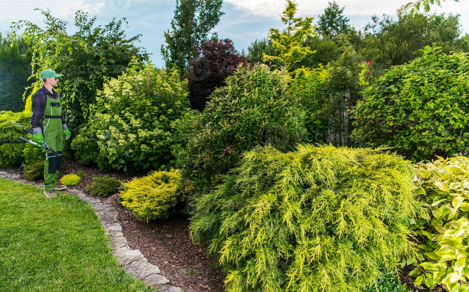 Fachmann Landschaftsgestalter im Vorderseite von Insel Garten Bett foto