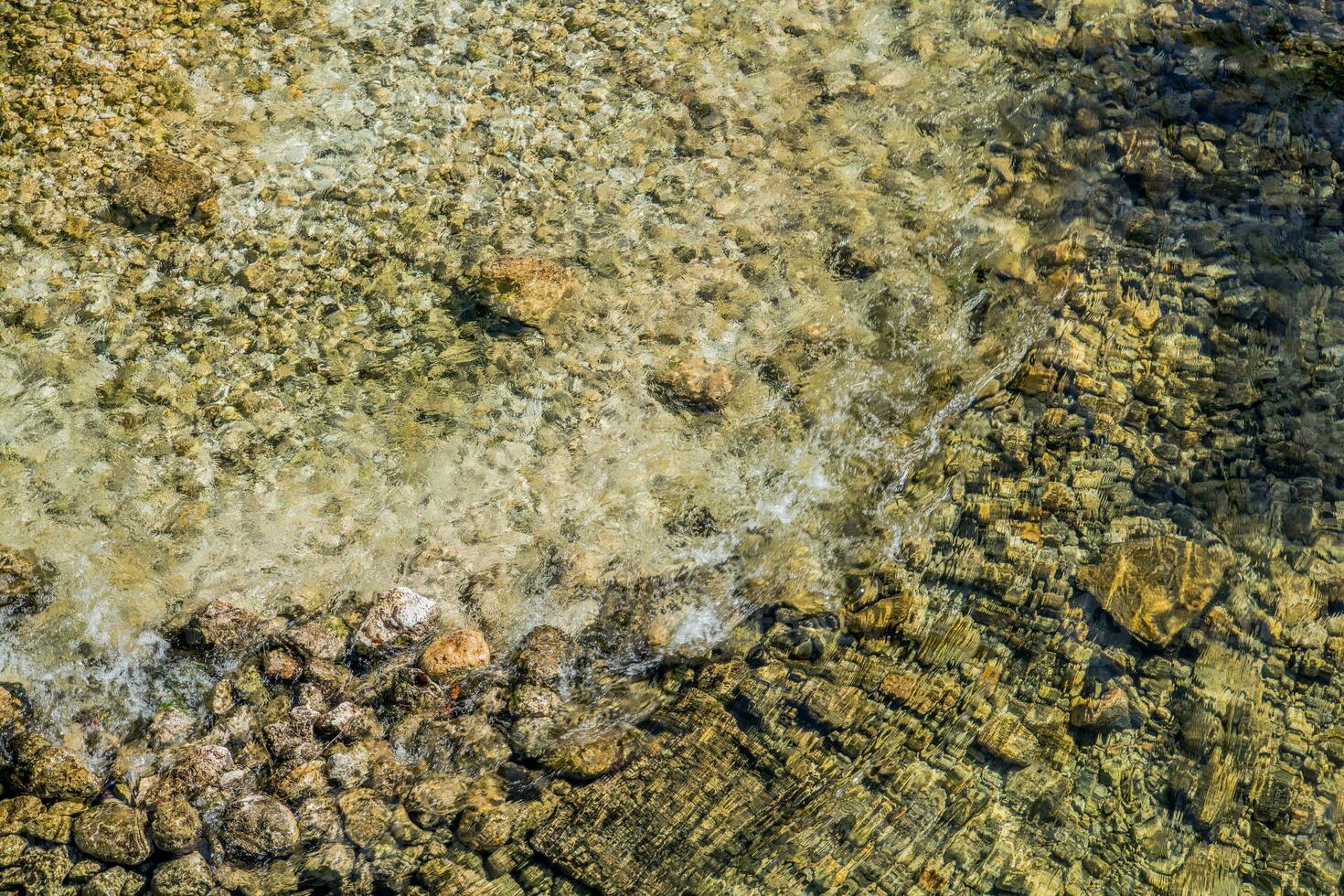 felsig Fluss Bett mit Kristall klar Wasser. foto