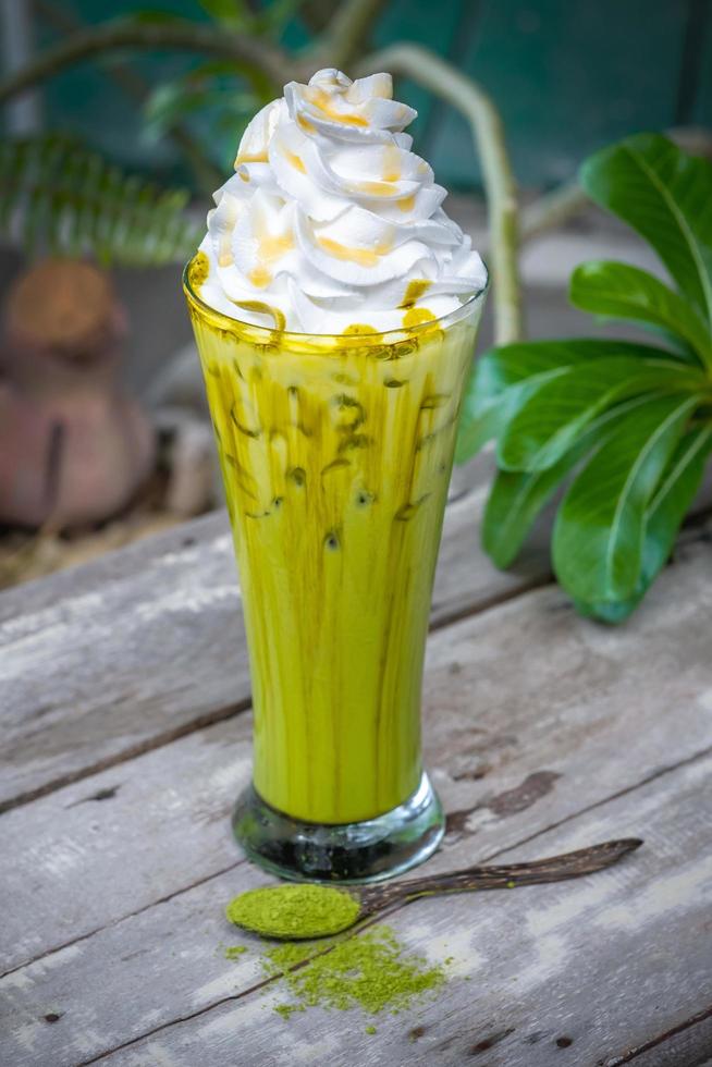 Eis Matcha grüner Tee mit Schlagsahne auf hölzernem Tischhintergrund foto