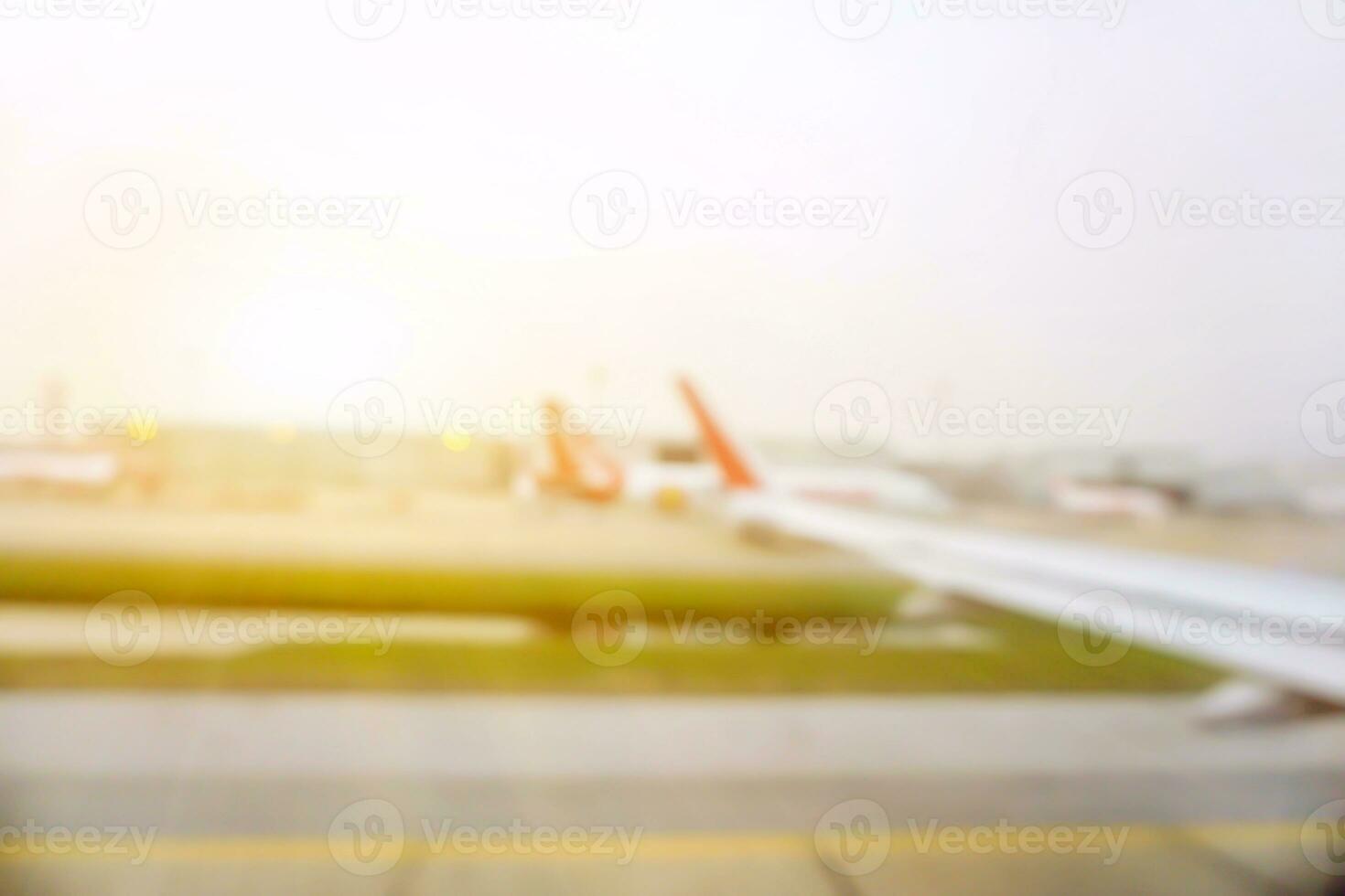 verschwommen und draußen Aussicht von Flugzeug auf das Flughafen Runway während das Flugzeug ist bereit zu ausziehen, starten, abheben, losfahren mit Himmel Sonne Fackel Hintergrund. foto