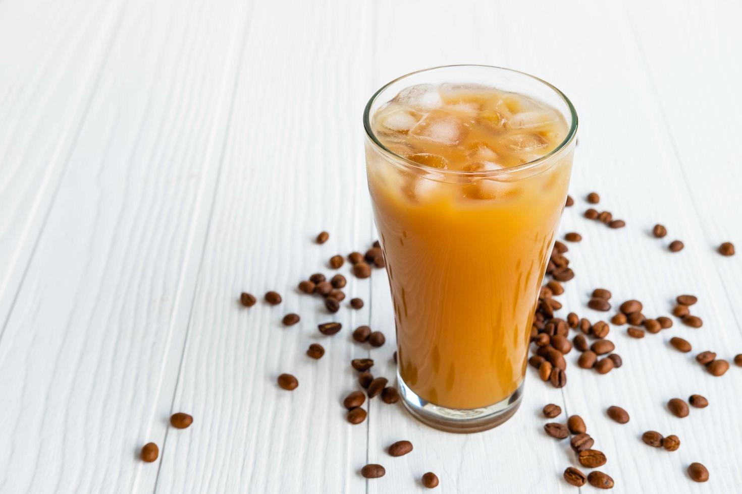 Eiskaffee in einem Glas auf einem weißen hölzernen Hintergrund foto