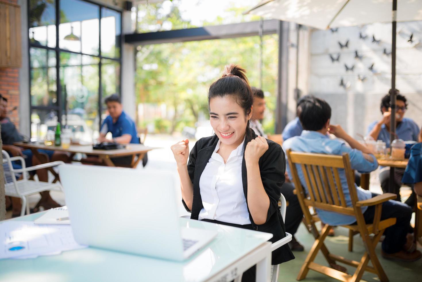 beschäftigte junge Geschäftsfrau, die an einem Straßencafé arbeitet foto