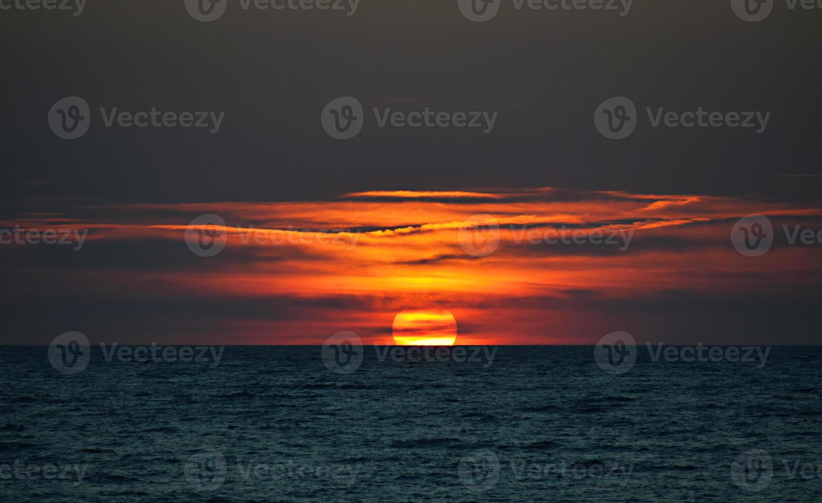 schöner orange Sonnenuntergang auf Gewässer foto