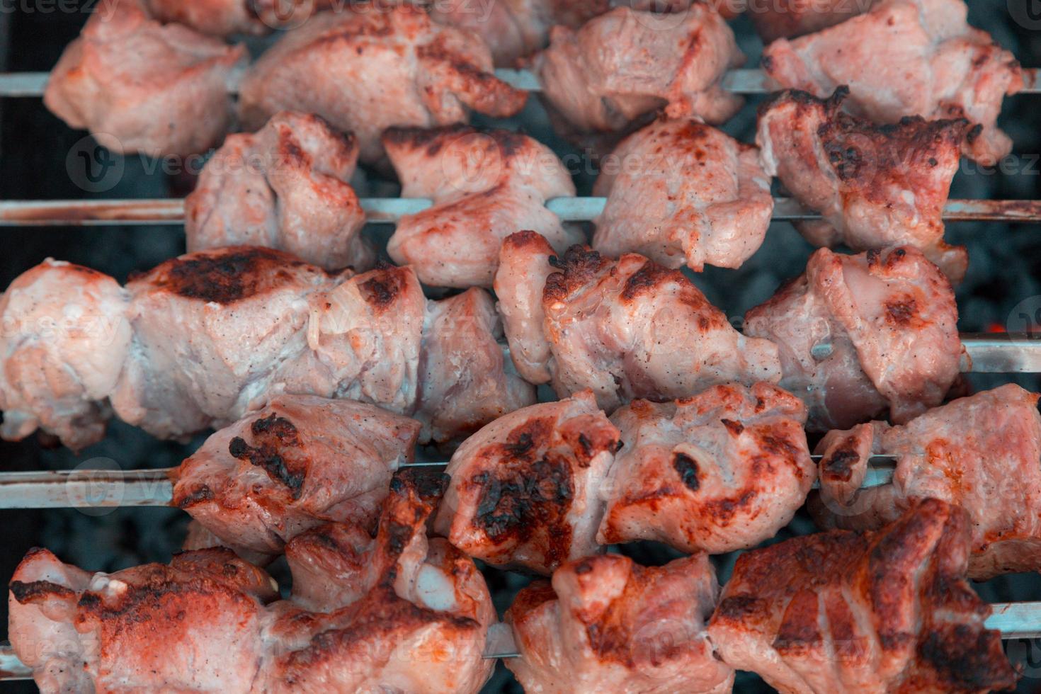 Schaschlik am Spieß und heiße Kohlen mit Rauch foto