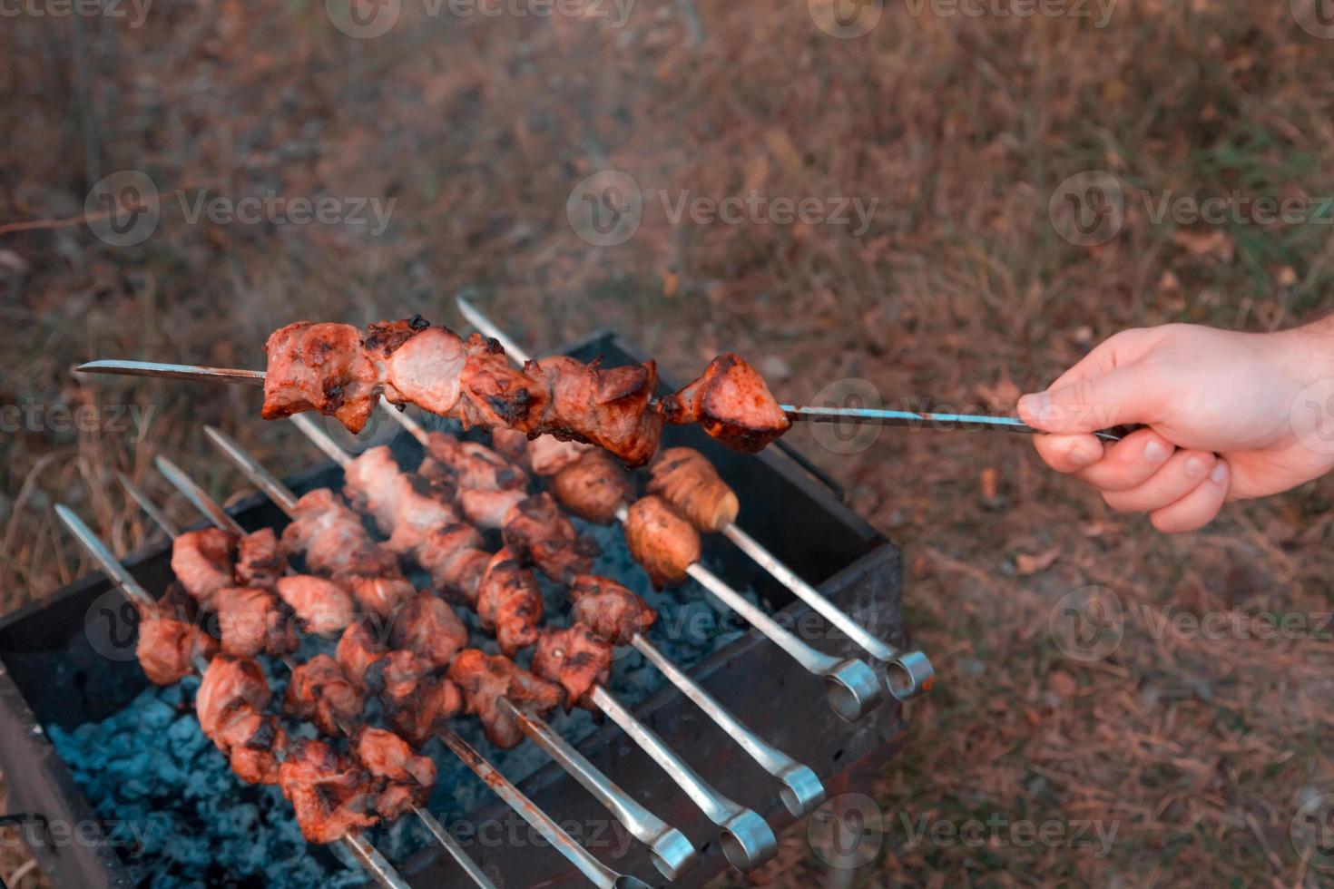 Mann, der Schaschlik auf dem Grill brät foto