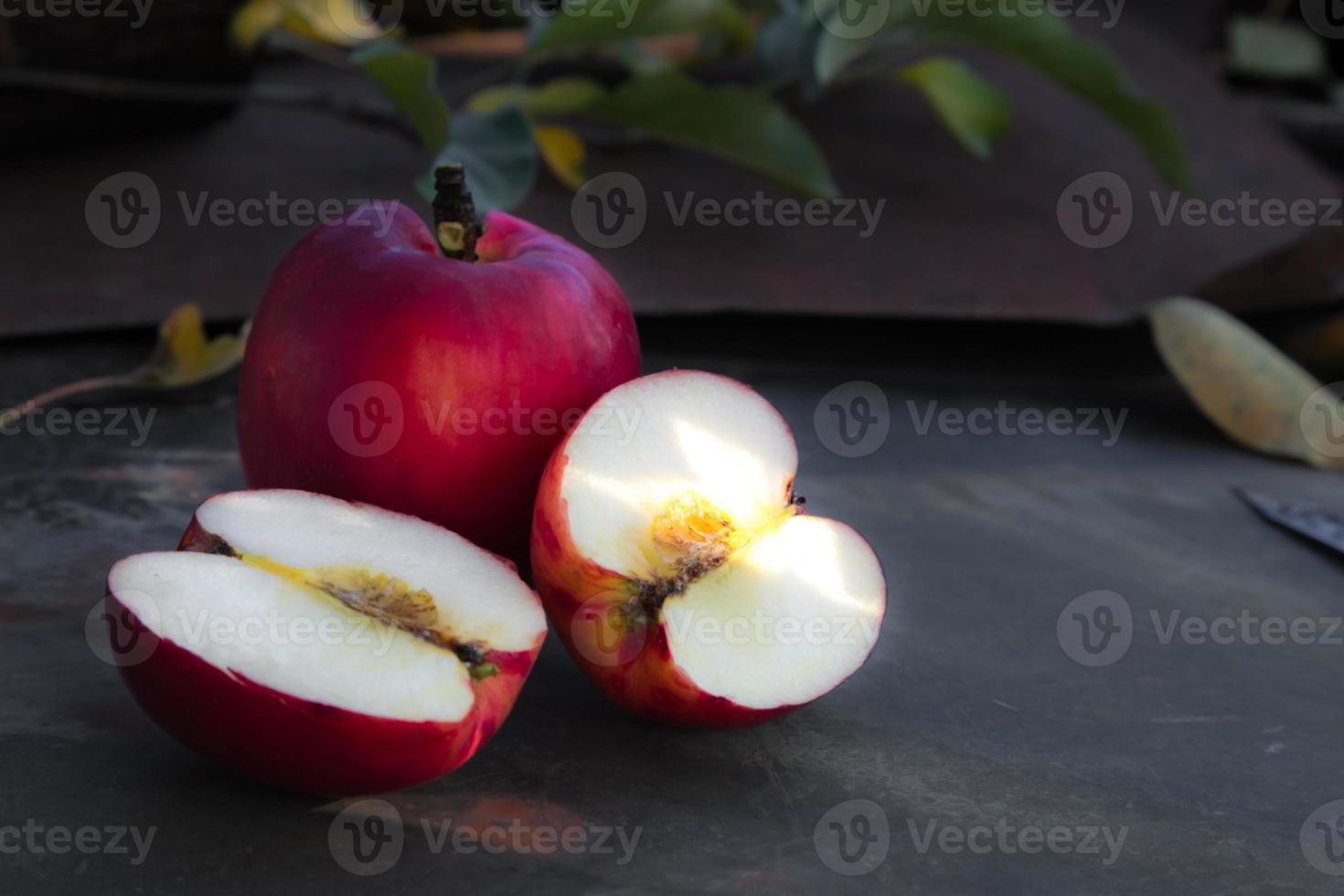 Nahaufnahme eines geschnittenen roten Apfels auf einem Holztisch foto