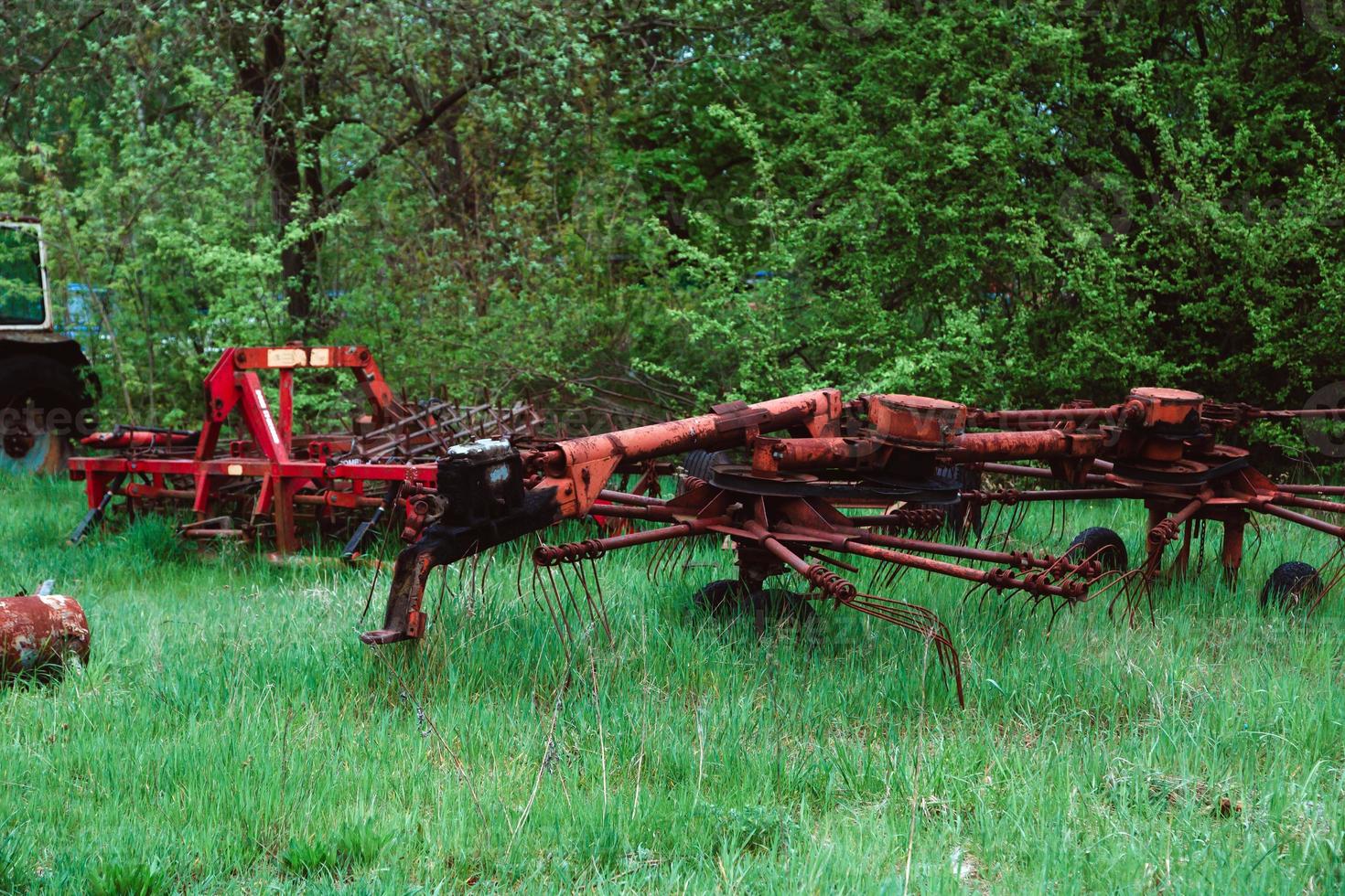 alte Traktoren und anderes landwirtschaftliches Material auf einem Schrottplatz foto