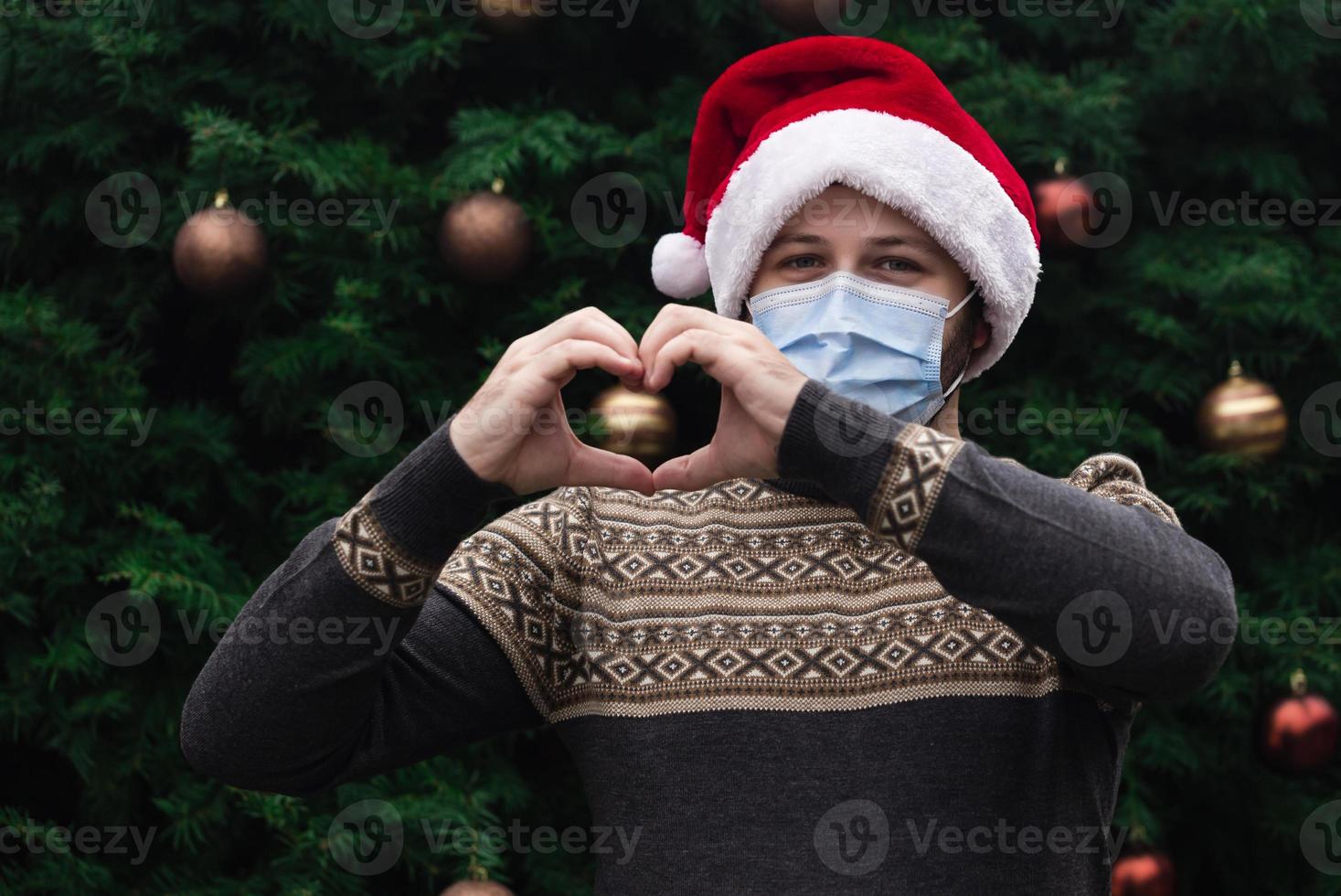 Nahaufnahmeporträt eines Mannes, der einen Weihnachtsmannhut trägt foto