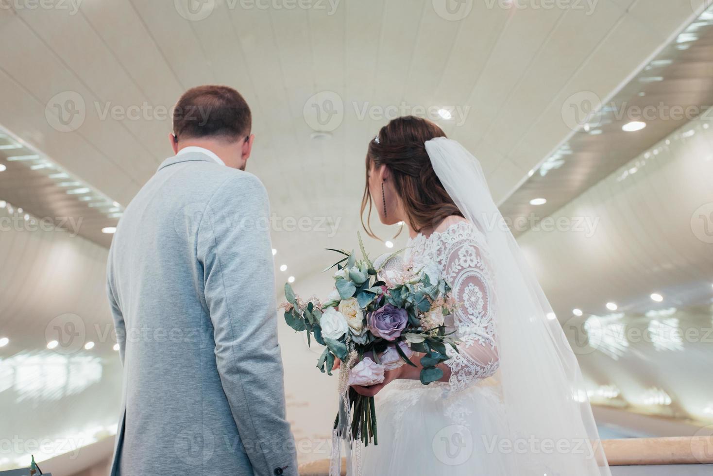 junge Braut und Bräutigam an ihrem Hochzeitstag in einem Kirchengebäude foto