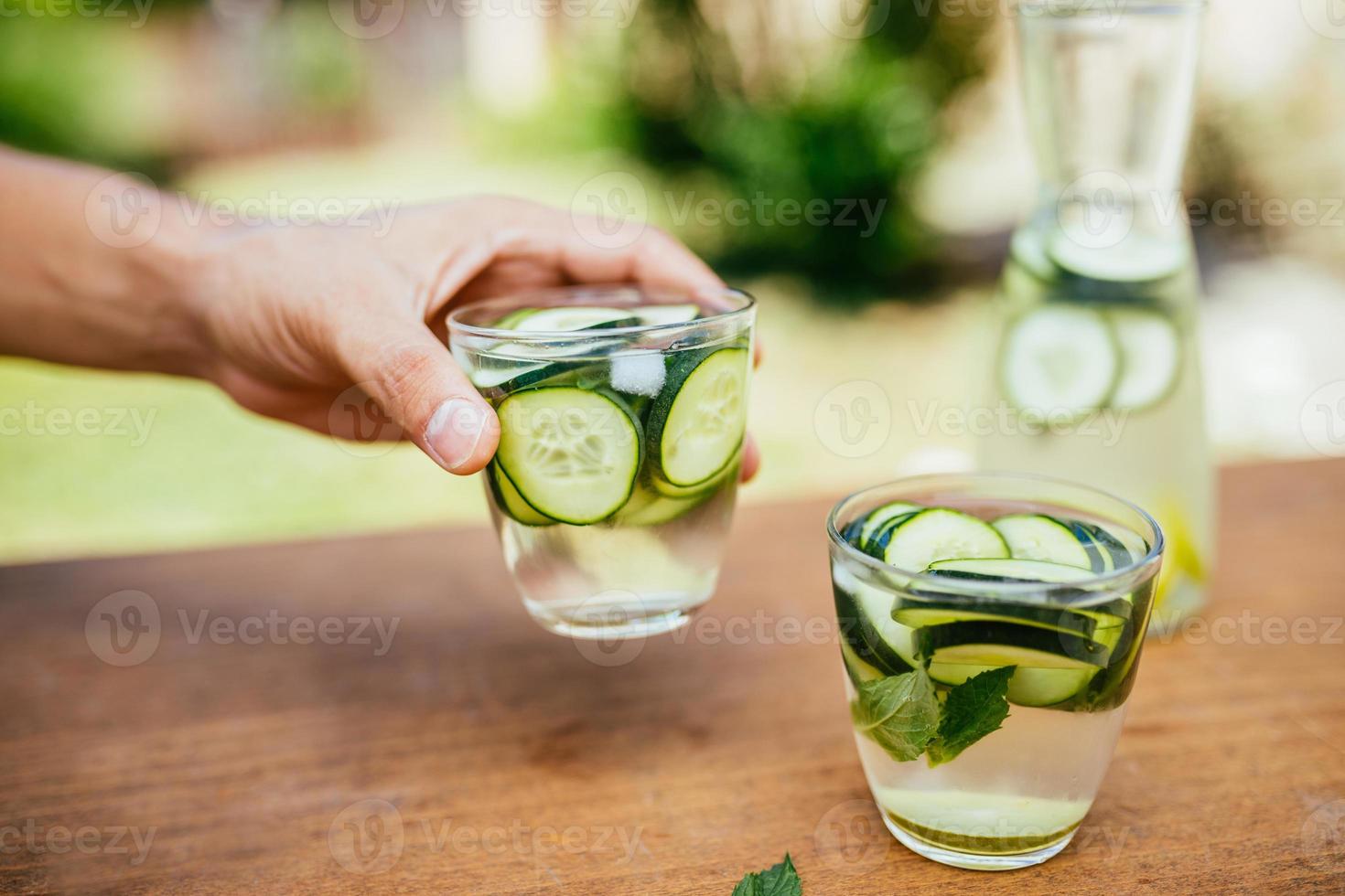 Halten Sie ein Glas mit infundiertem Entgiftungswasser foto