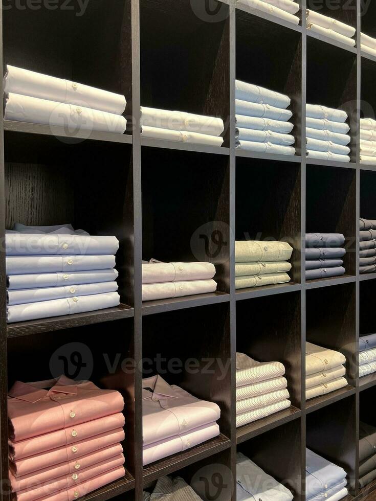 Hemden sind gestapelt auf das Regal. Stil und Kleiderschrank. Einkaufen. foto