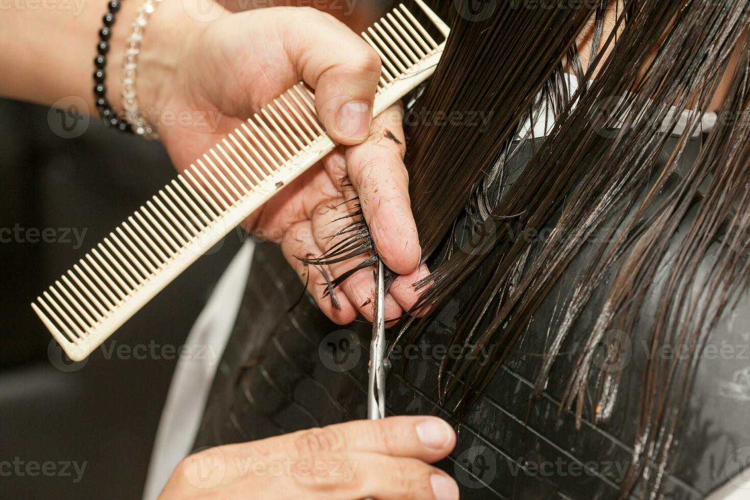 männlich Stylist Herstellung ein Haarschnitt zu ein Weiß Frau foto