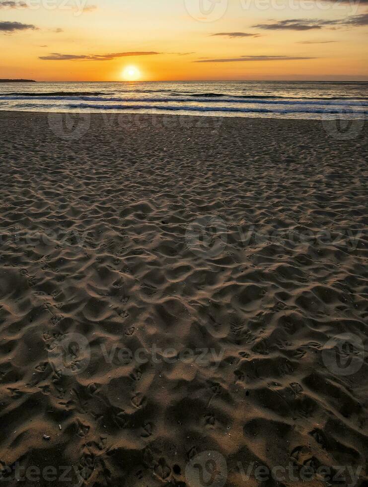 schön Meer Sonnenuntergang oder Sonnenaufgang Über das Meer von das Sand. Vertikale Aussicht foto