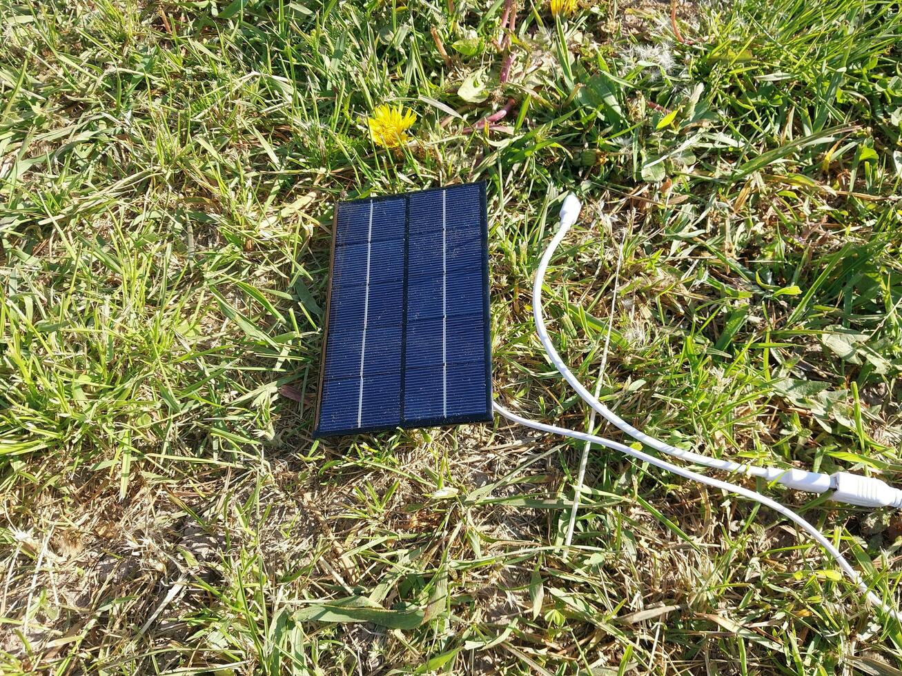 Solar- Panel zum Laden ein Smartphone auf das Gras foto