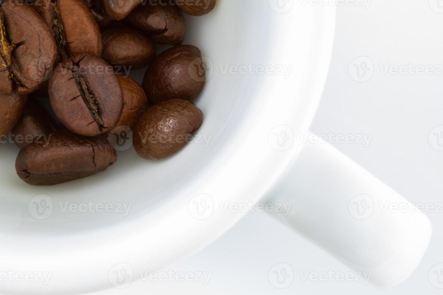 Draufsicht auf eine Kaffeetasse und Kaffeebohnen auf weißem Hintergrund foto