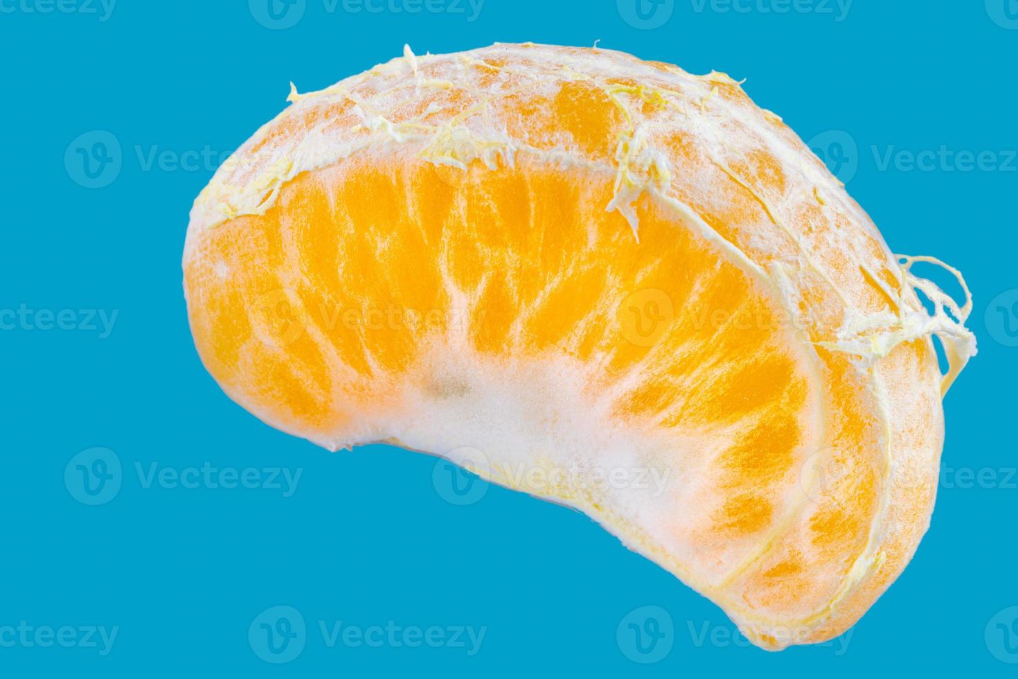 Scheibe der einzelnen frischen Mandarine auf blauem Hintergrund foto