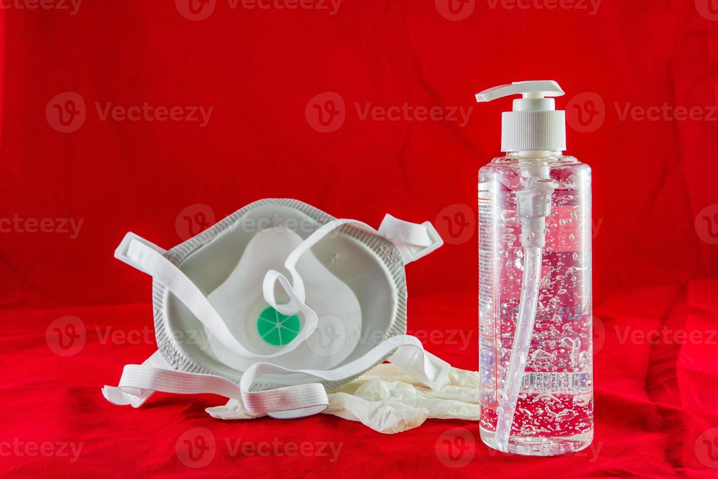 Desinfektionsgel weiße Latexhandschuhe und Maske auf rotem Schutzkonzept gegen Verschmutzungsvirusgrippe und Coronavirus foto