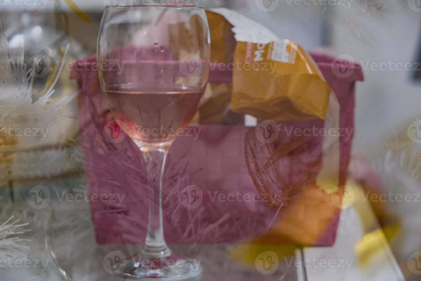 Ein Glas Roséwein, eine Geschenkbox und ein weißer Weihnachtsbaum hinterlassen eine Doppelbelichtung, die als Hintergrund geeignet ist foto