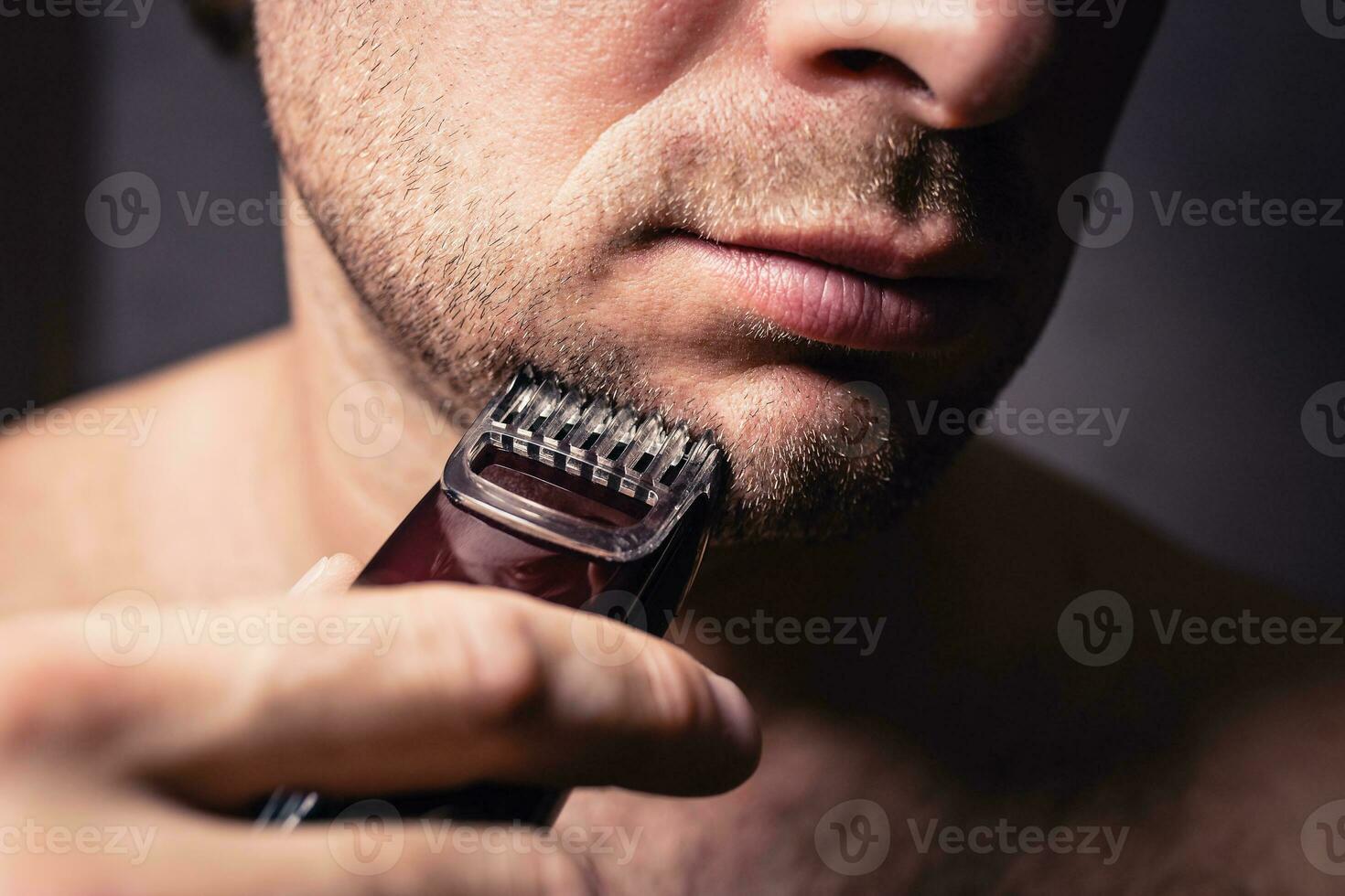 schließen oben Modellieren ein Bart und Borsten mit ein elektrisch Rasieren Trimmer foto