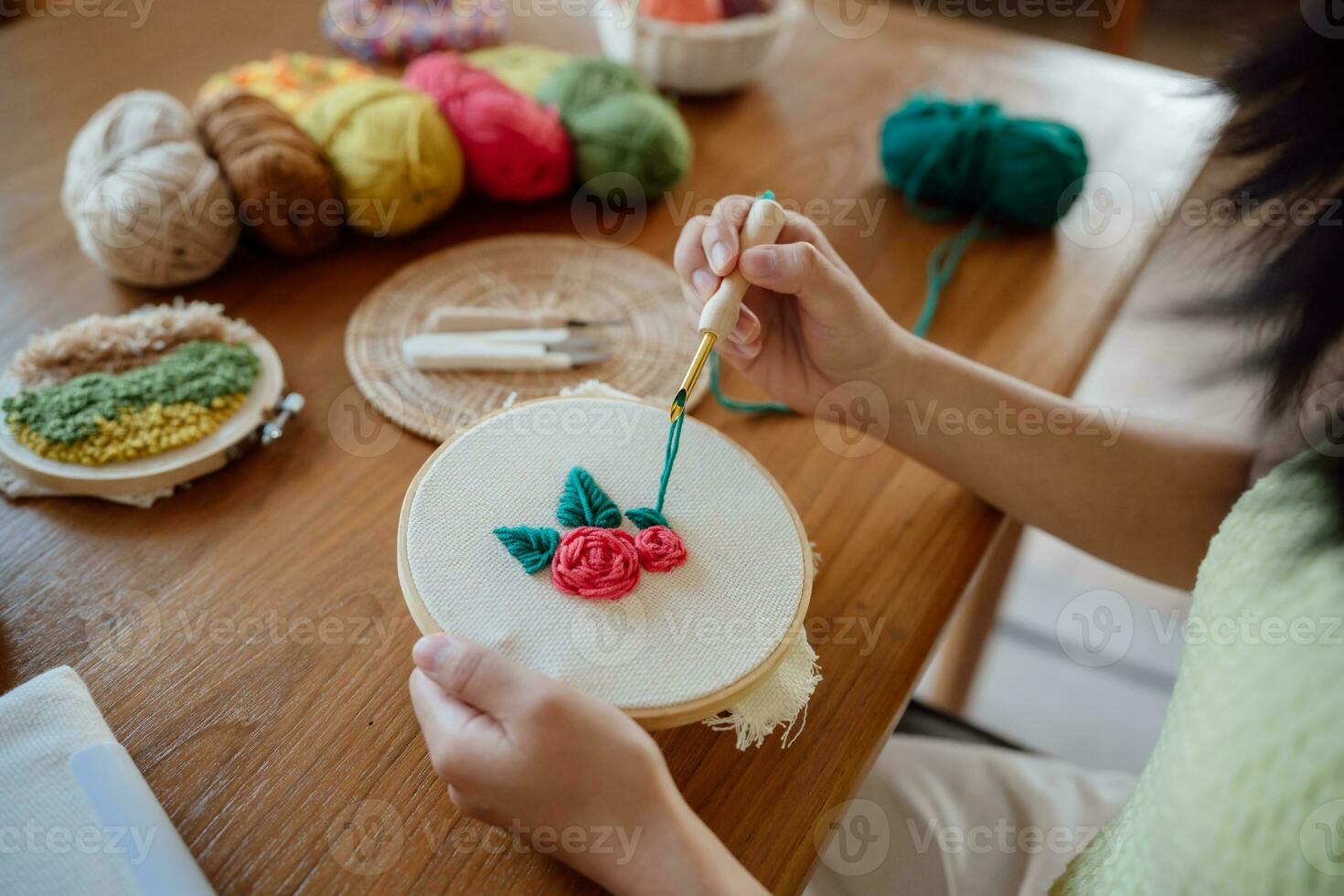 schlagen Nadel. asiatisch Frau Herstellung handgemacht Hobby Stricken im Studio Werkstatt. Designer Arbeitsplatz handgemacht Kunst Projekt DIY Stickerei Konzept. foto