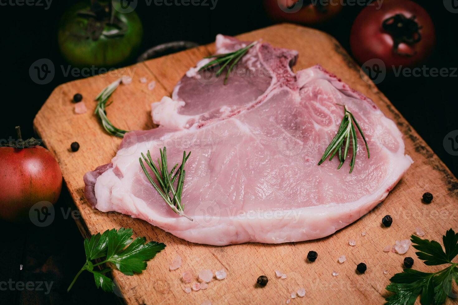 Schweinefleisch Koteletts auf ein Schneiden Tafel mit Knoblauch, Gewürze. selektiv Fokus foto