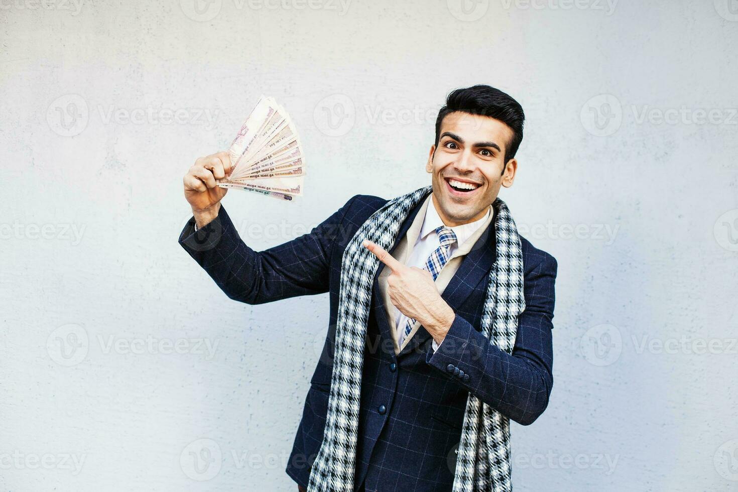 gut aussehend indisch Mann zeigen ein Menge von Geld foto