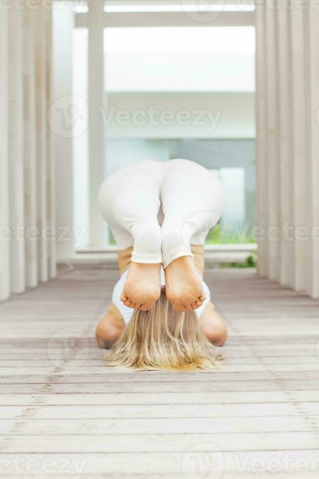 Frau tun Yoga Asana im ein geräumig Studio foto