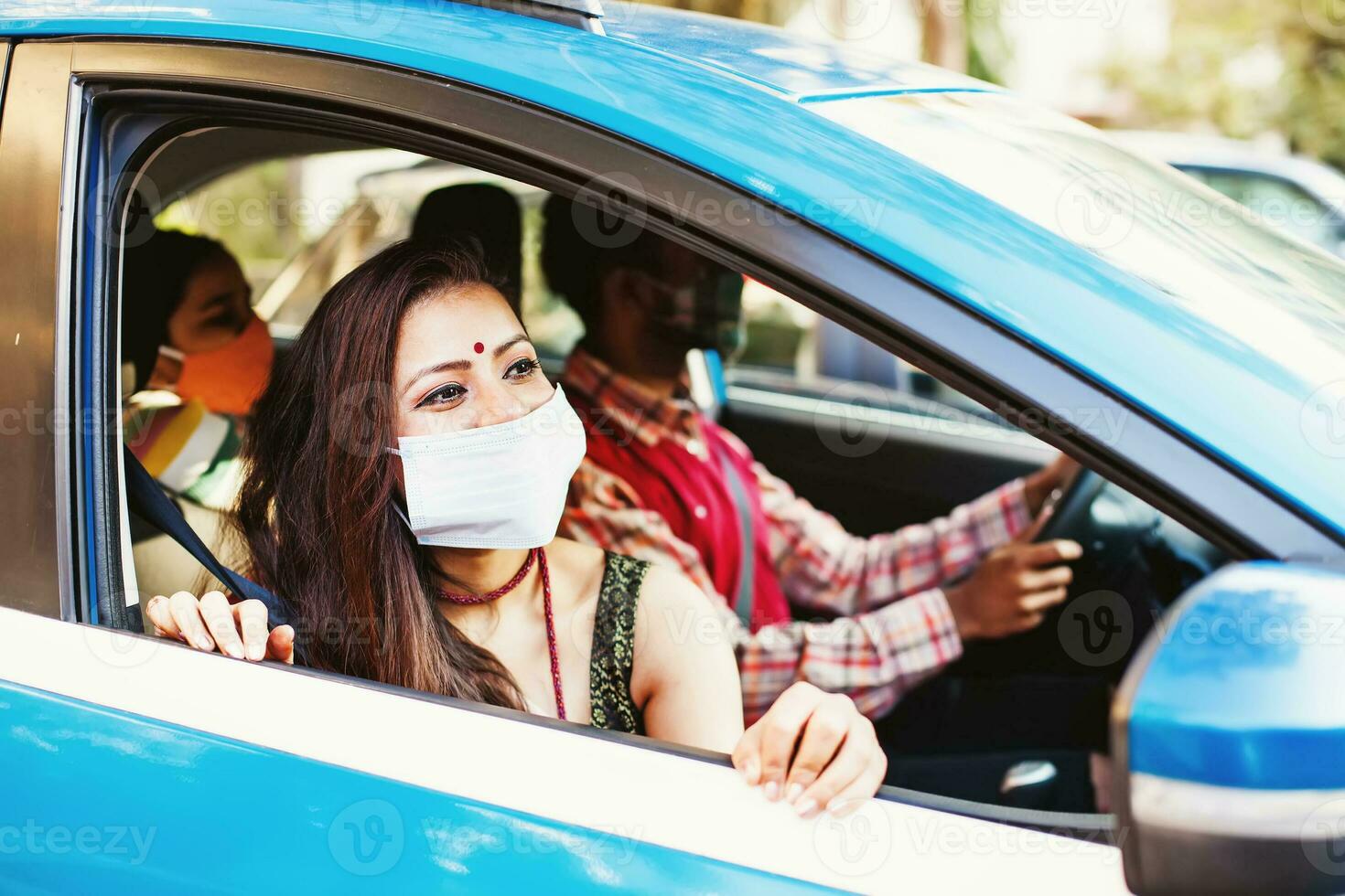 glücklich indisch Familie tragen Coronavirus schützend Gesicht Masken Reisen im ein Auto zusammen foto