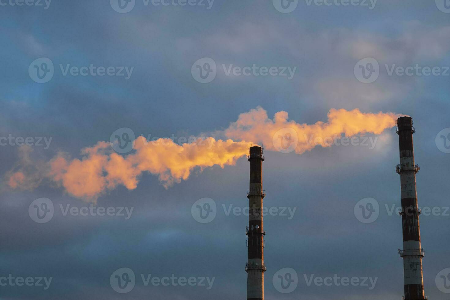 Kamin von ein Thermal- Leistung Pflanze im Abend Licht, das Rauch extrahiert durch ein Thermal- Leistung Pflanze auf das Schornstein, im das Produktion Verfahren. Umfeld, Verschmutzung. foto