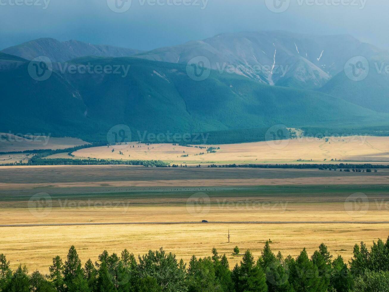 genial dramatisch alpin Aussicht von bestehen zu Berg Schlucht, Steppe im Sonnenlicht und großartig Berg Silhouetten auf Horizont. foto