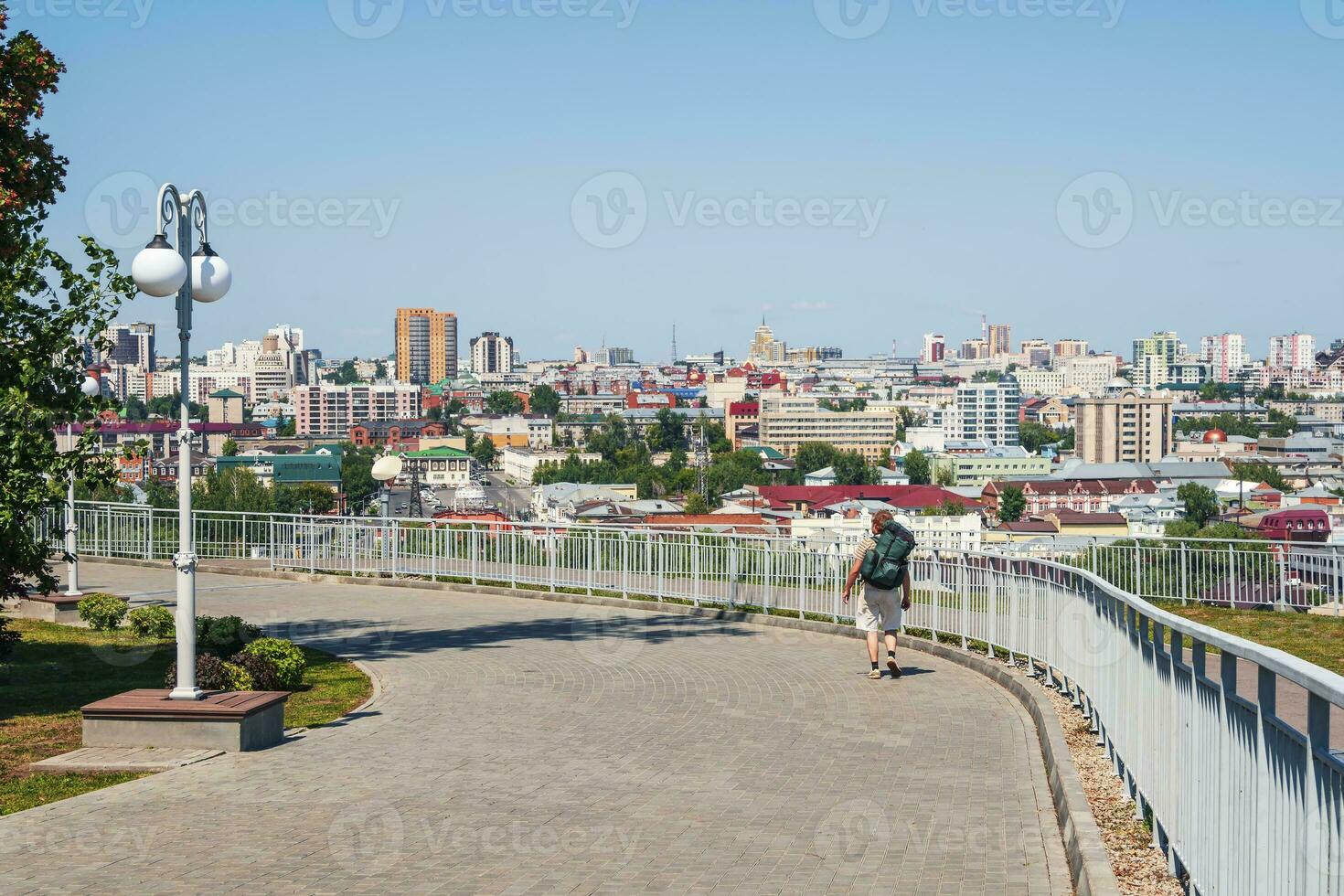 zurück Aussicht gut aussehend touristisch Mann mit Rucksack Spaziergänge Stadtbild Hintergrund Sommer- Jahreszeit im schön Stadt. foto