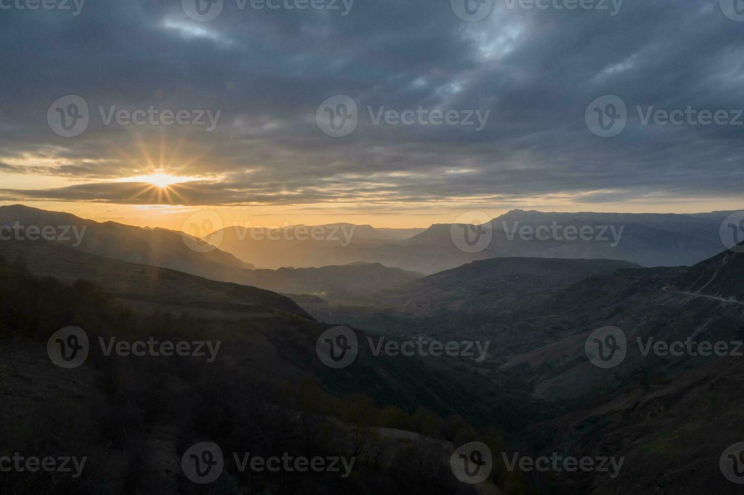 zuletzt Strahlen von das Rahmen Sonne Über ein bergig Plateau. golden Sonnenuntergang im Berg Landschaft. Silhouette von das Abend Berge beim Sonnenuntergang. matlas Senke beim Sonnenuntergang im Dagestan. foto