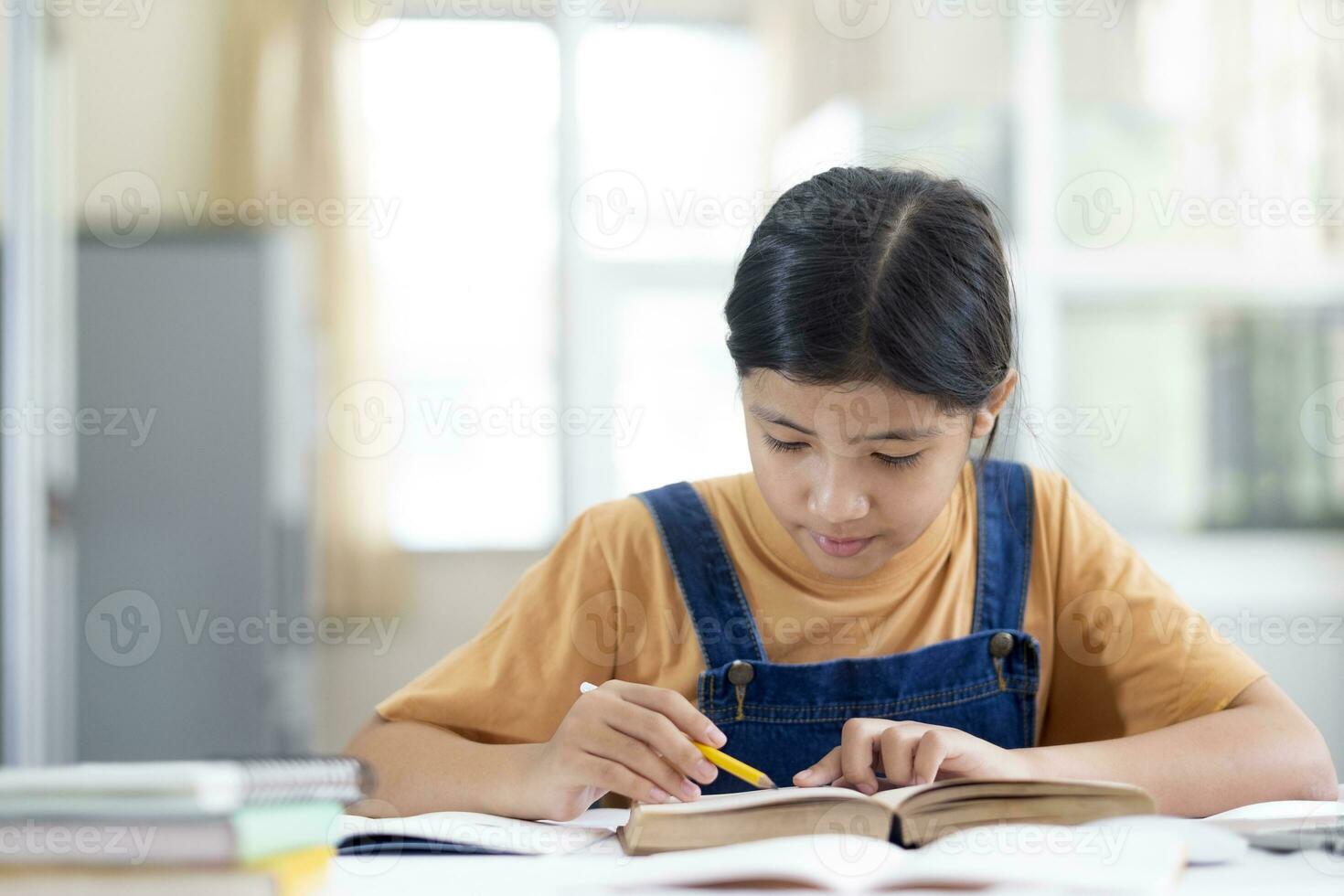 asiatisch Mädchen lesen und tun Hausaufgaben beim ihr Zuhause foto